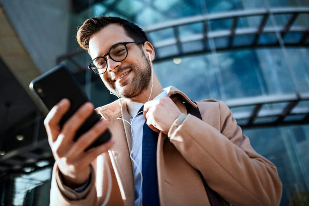 Executivo sorrindo olhando para o celular